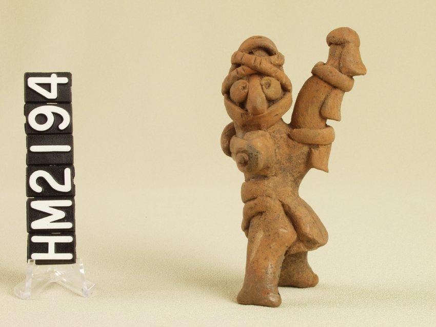 Tiny ceramic figure with elaborate costume.
