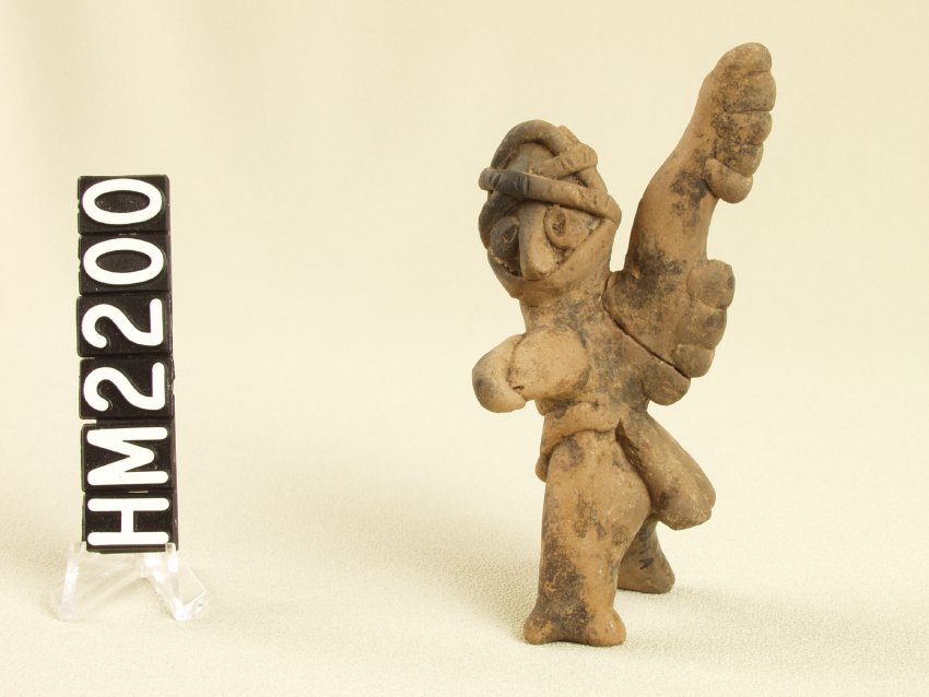 Tiny ceramic figure with elaborate costume.