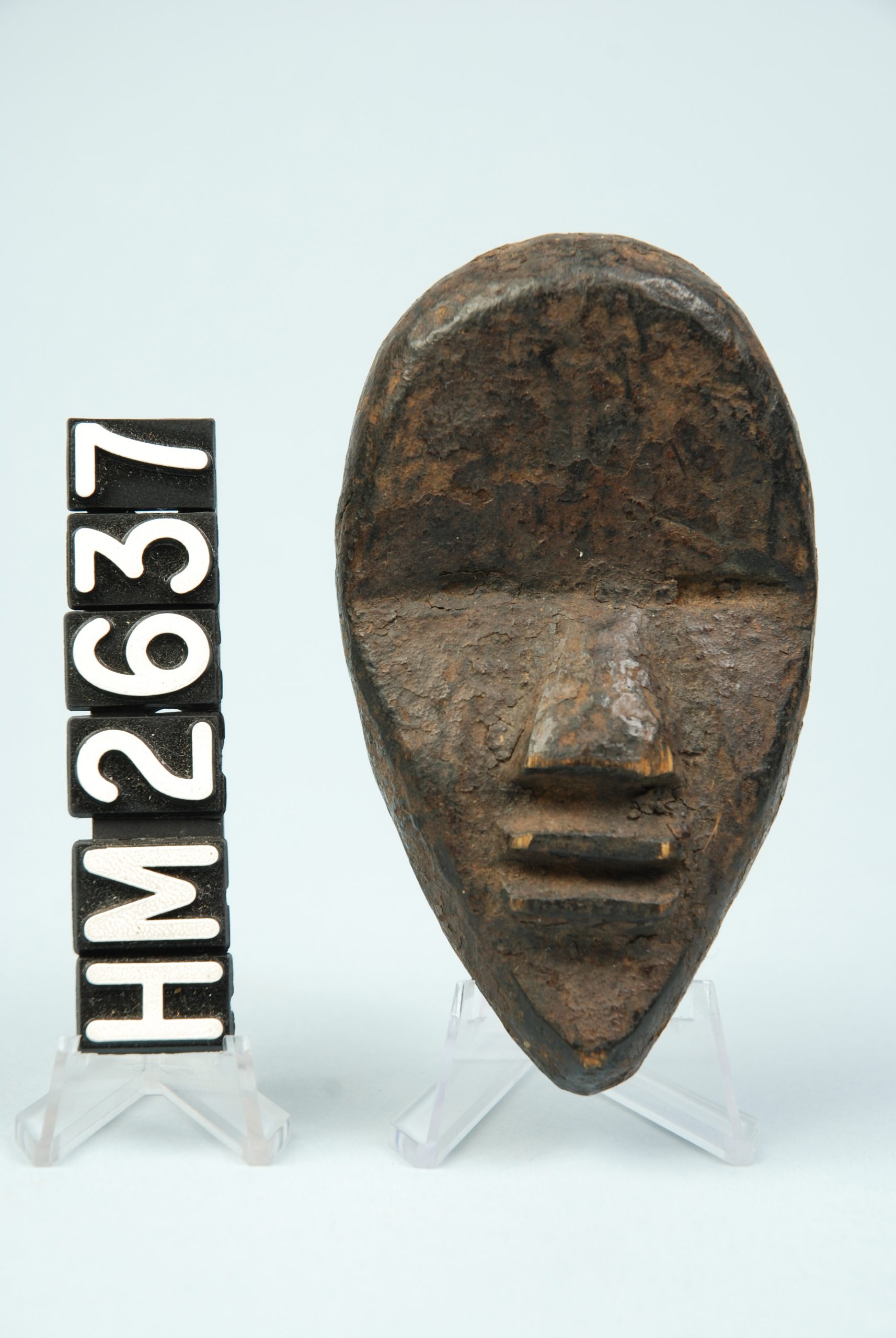 Image of stylized, angular face carved from wood.