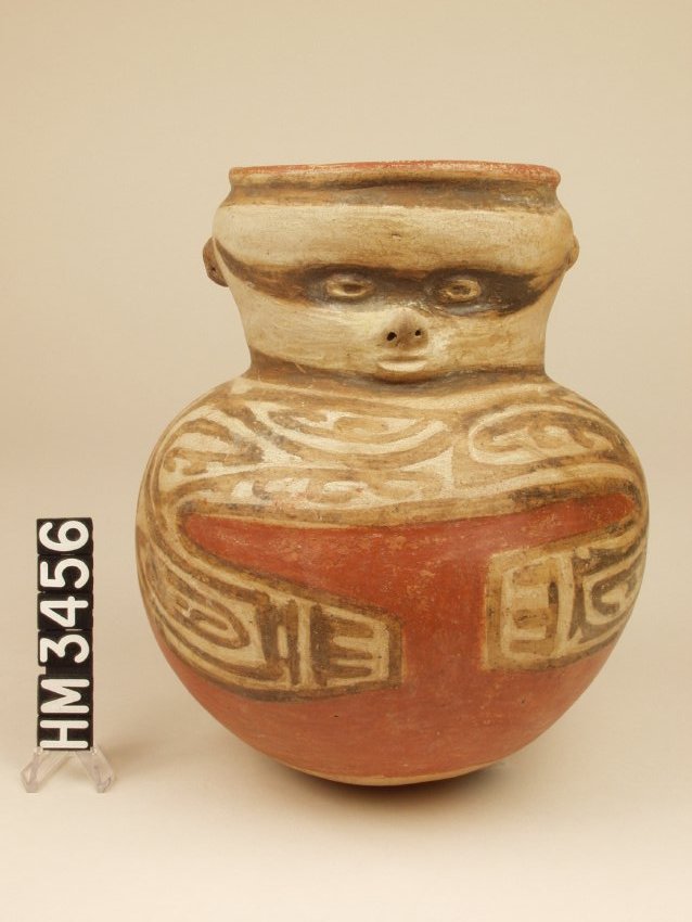 Polychrome ceramic effigy jar with face on neck and arms around belly on body. Black on white on red decorations.