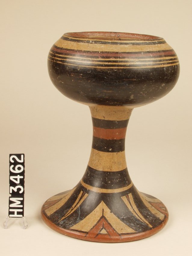 Ceramic goblet or pedestal bowl with round bowl and expanding foot at bottom of pedestal. Painted with black, white, and red stripes.