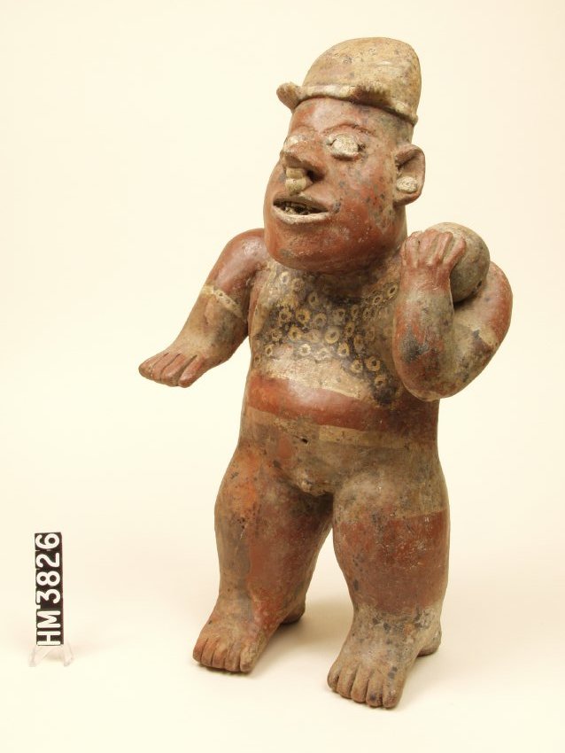 Standing ceramic figure holding a ball against his left shoulder with his left hand.