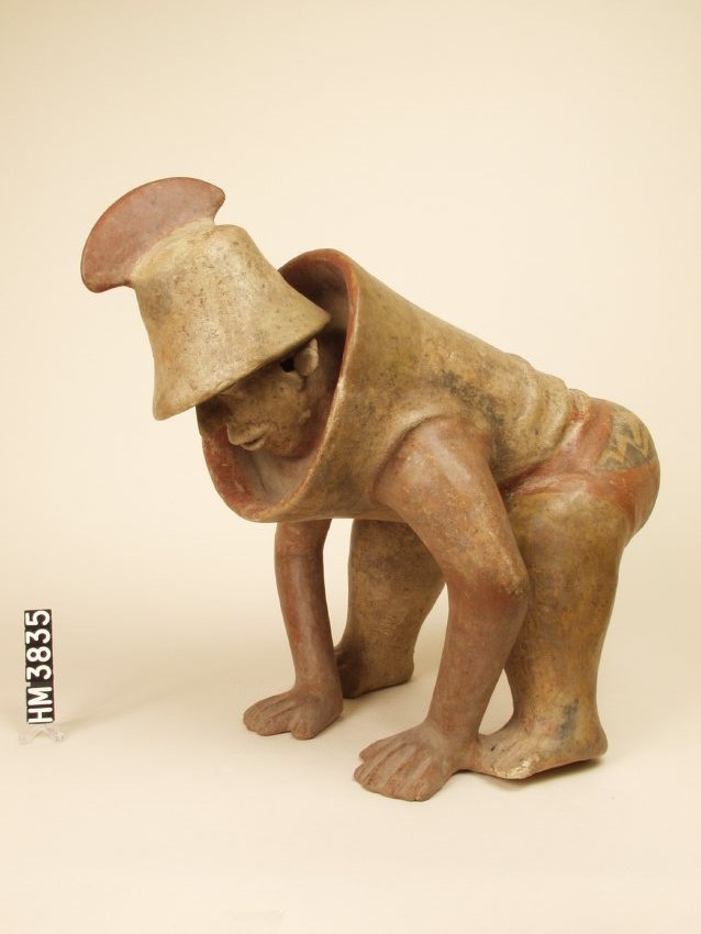 Ceramic figure with legs flexed and slightly spread, back bent, and arms slightly flexed with flat palms on ground. Wearing high collar armor to waist and flared brim hat with tall curved crest.
