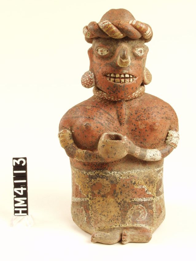 Seated ceramic figure with short legs bent toward figure's right. Thin arms bent 90 degrees at elbow holding bowl, left hand on bottom of bowl, right hand on side. Eyes almond-shaped, painted white. Large nose with nose ring painted white. Disc earrings with white rim and dots, necklace with white dots. Three to five white bands on each arm, four strand beaded bracelet on each wrist. Fingernails painted white. Wearing only a skirt and a pointy hat with double twisted horizontal band, one plain red, one painted with white stripes.