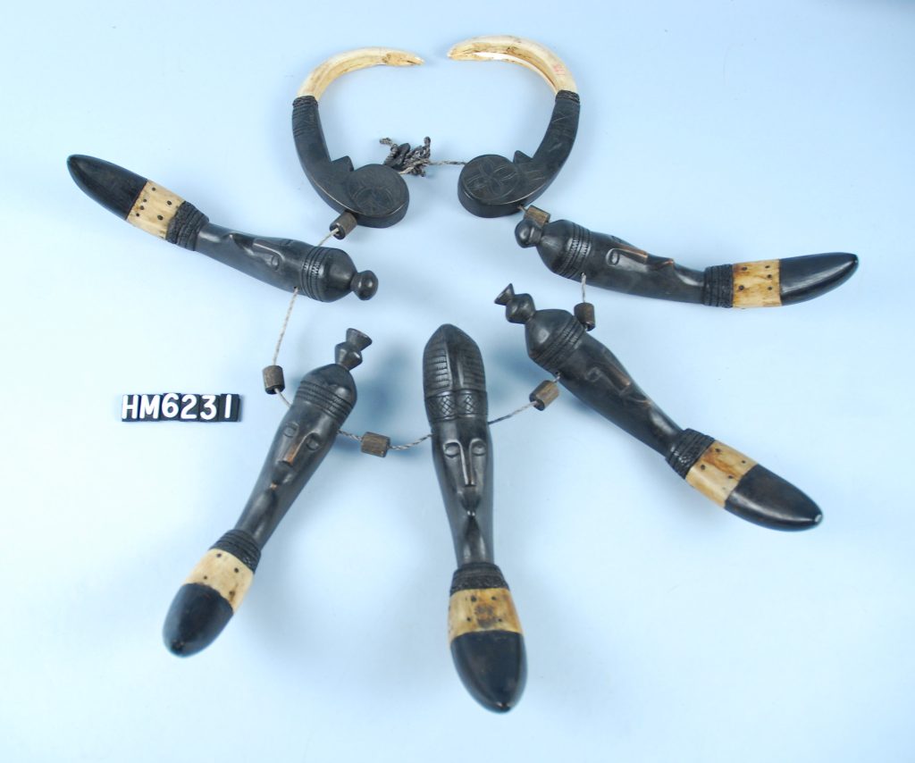 Image of a string of large carved wooden ornaments with bone elements.