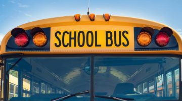 Front of a yellow school bus against a blue sky