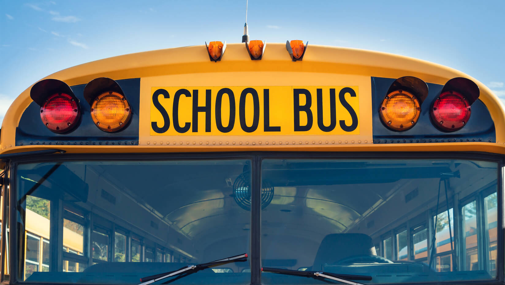 Front of a yellow school bus against a blue sky