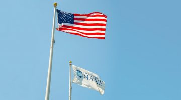 American flag and UMaine flag