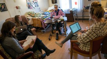 Students working with a resident at Orono Commons