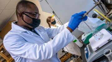 Students conducing lab research wearing lab coats