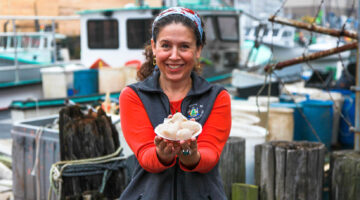 A woman holding a plate of scallops
