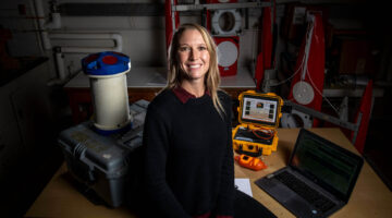 Lauren Ross sits in her lab in front of research equipment