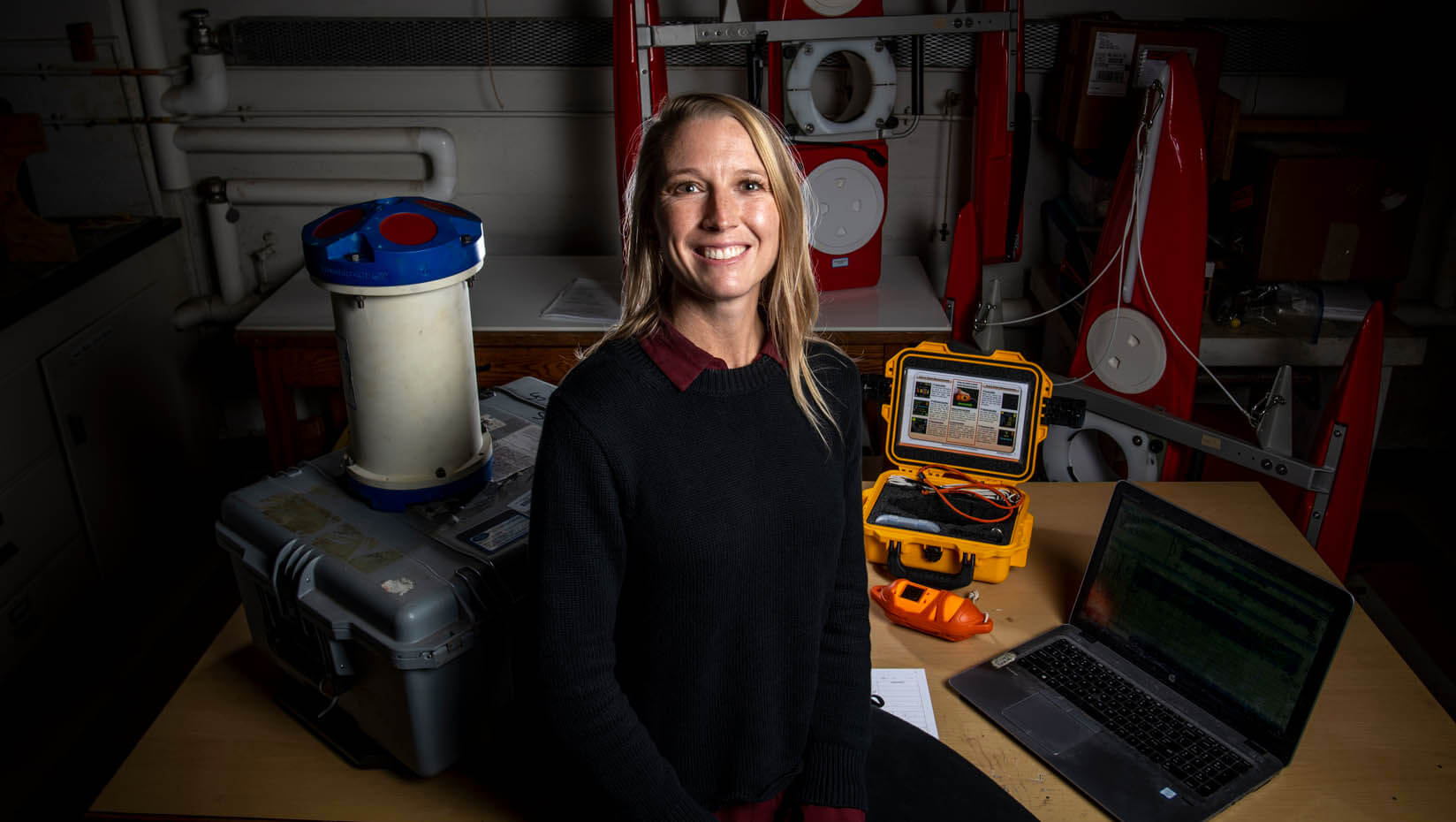 Lauren Ross sits in her lab in front of research equipment