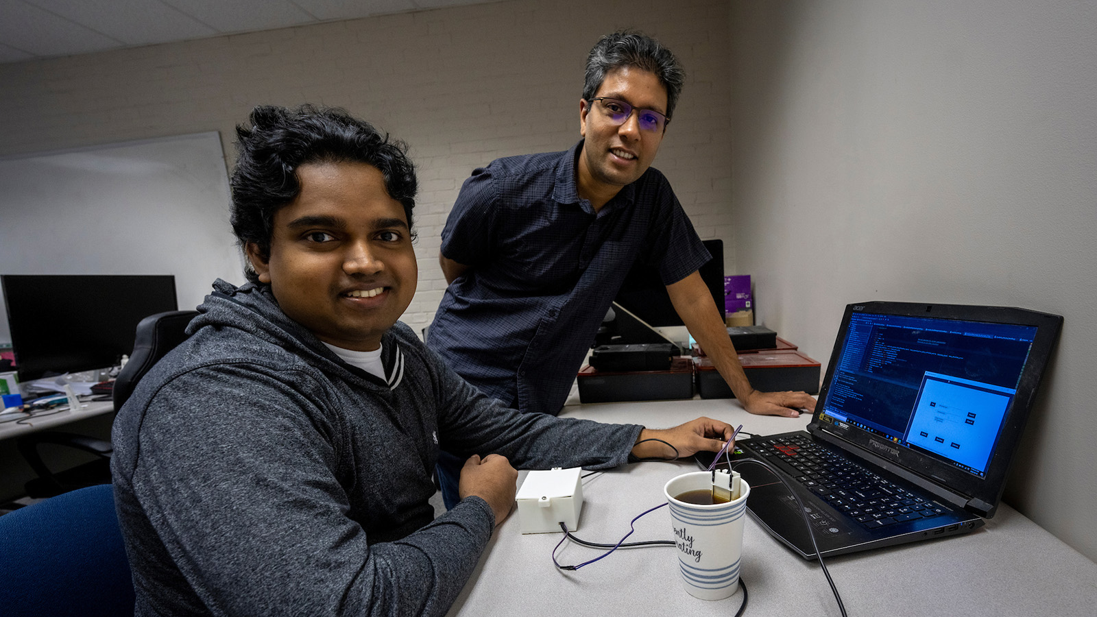 Photo of Nimesha Ranasinghe and Chamath Amarasinghe with the SipBit device.