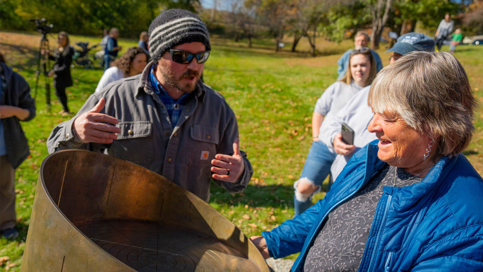 A photo of two people looking at SunRule in Webster Park