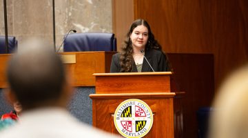 A photo of Miriam Talalay speaking at an awards ceremony