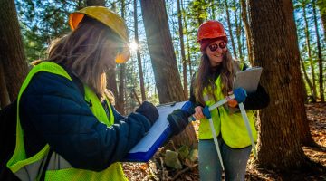 A photo of two women working in the Maine woods