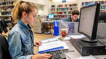 A photo two people using computers in Fogler Library
