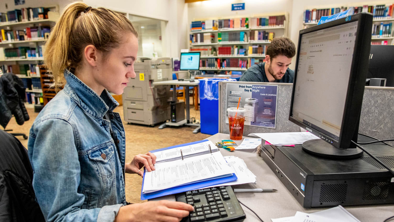 A photo two people using computers in Fogler Library
