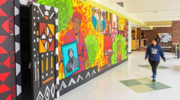 A photo of a person walking by the mural in Williams Hall