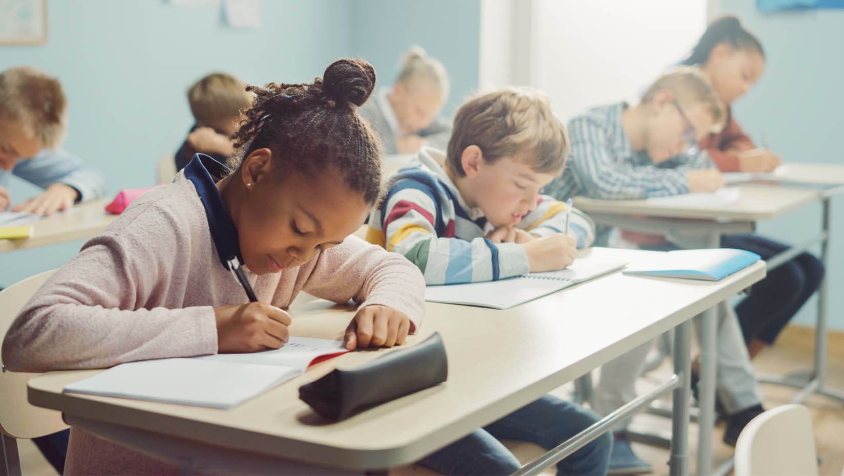 A photo of elementary school students writing at desks
