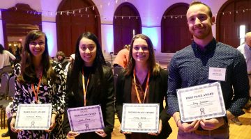 A photo of four people holding award certificates