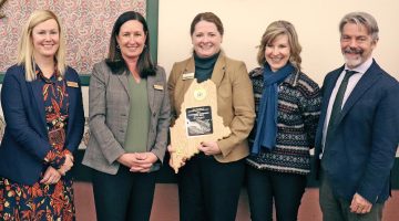 Photo of people posing and smiling while having their picture taken.