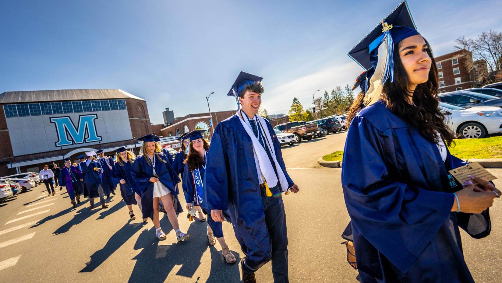 A photo of students walking outside during commencement
