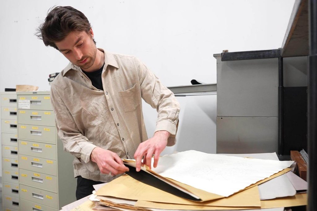 A photo of Peter Howe looking through folders