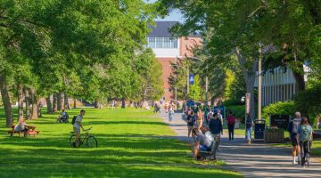 A photo of UMaine's Mall filled with student in late summer