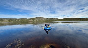 A photo of two people kayaking on the waters of a lake near Kangerlussuaq, Greenland