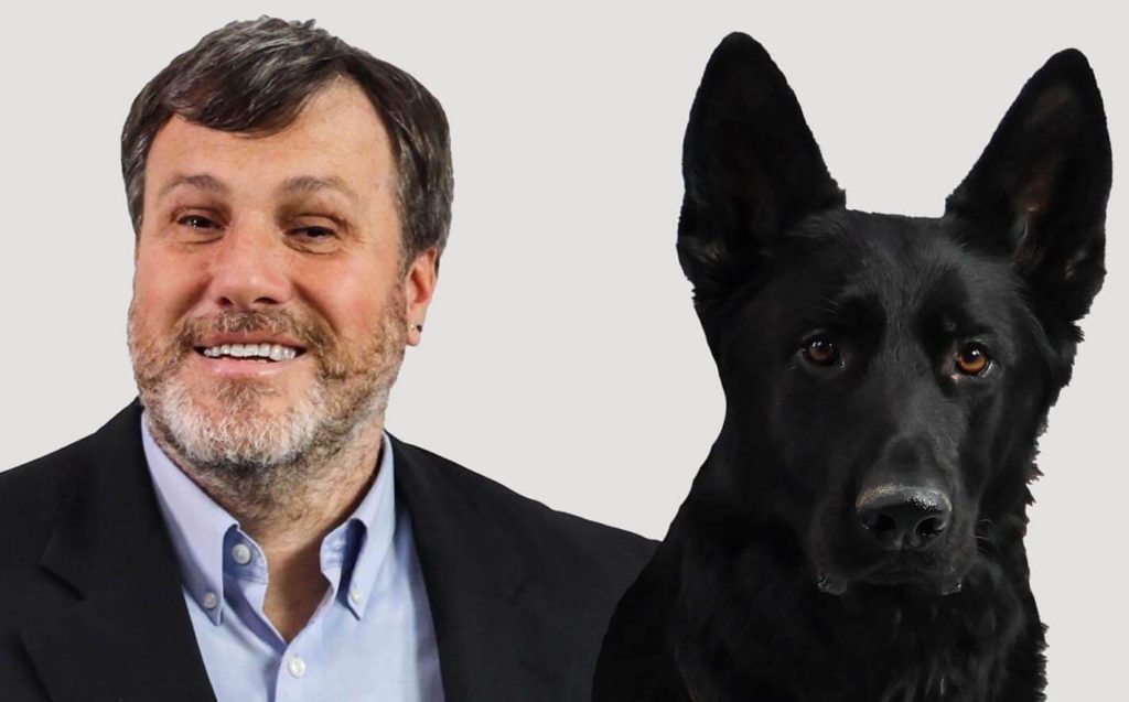 A portrait of Nicholas Giudice and his service dog