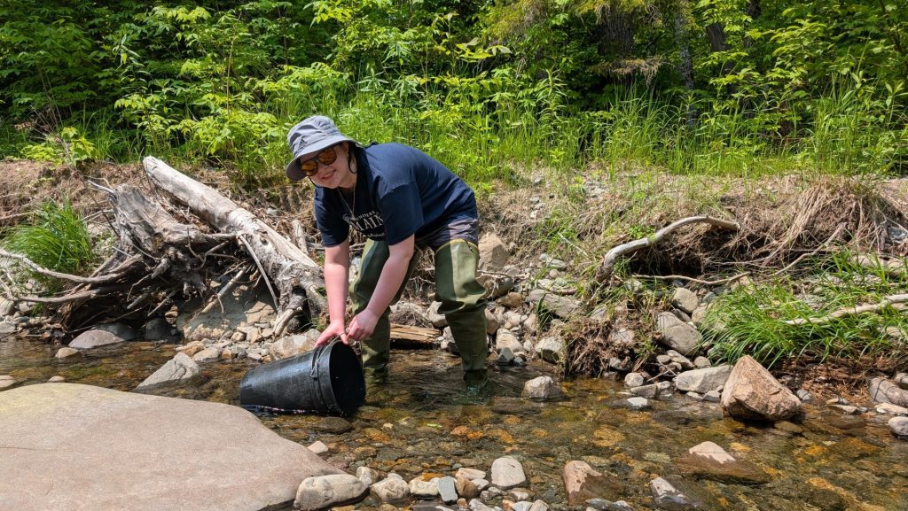 A student works by the river
