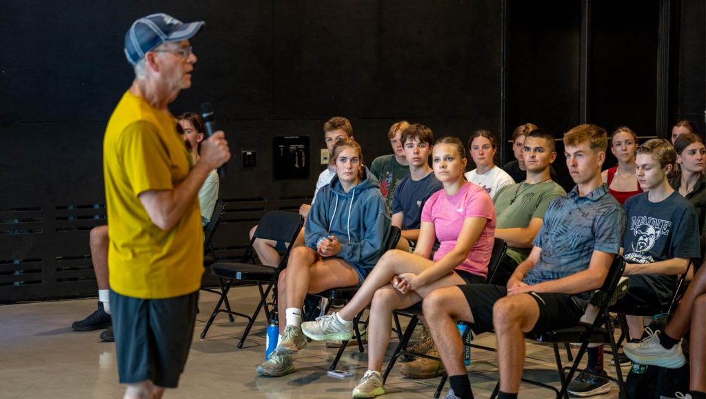 A photo of high school students listening to a speaker