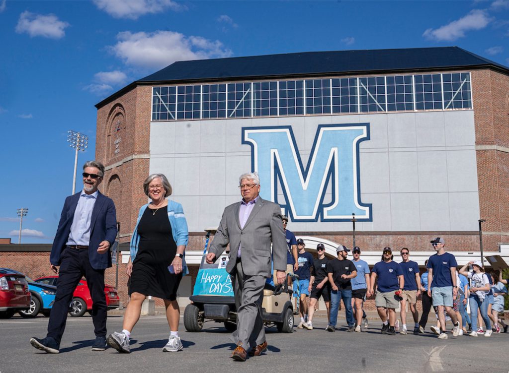 A photo of Joan Ferrini-Mundy walking with a group during a parade