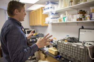 Brady looks over the continuous high frequency monitoring device as he explains the sampling process.