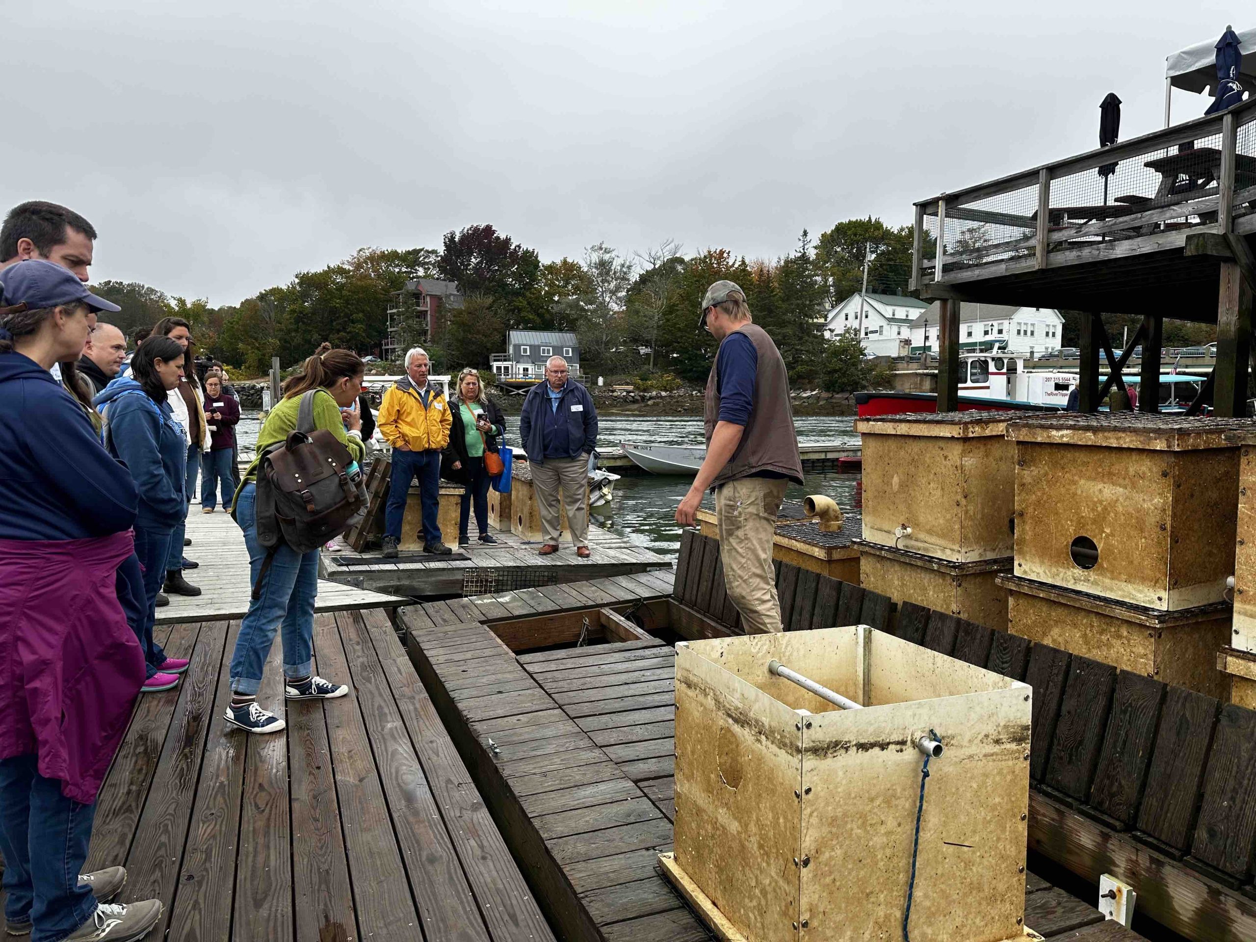 Image of people listening to a presentation from a fisherman